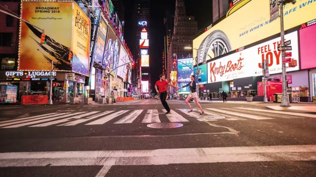 couple crossing road in NYC at night